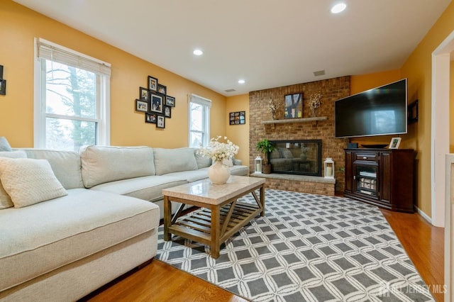 living area with a fireplace, wood finished floors, visible vents, and recessed lighting