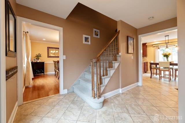 stairway with baseboards and tile patterned floors