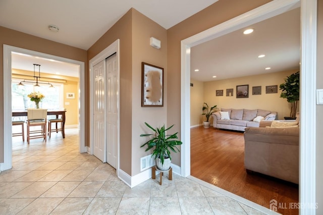 hallway with recessed lighting, light tile patterned flooring, and baseboards