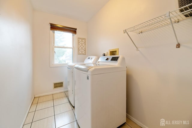 laundry room with laundry area, light tile patterned floors, baseboards, visible vents, and separate washer and dryer