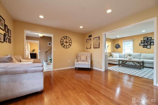 living area with stairs, baseboards, wood finished floors, and recessed lighting