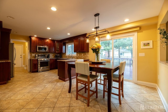 kitchen with recessed lighting, baseboards, hanging light fixtures, appliances with stainless steel finishes, and decorative backsplash