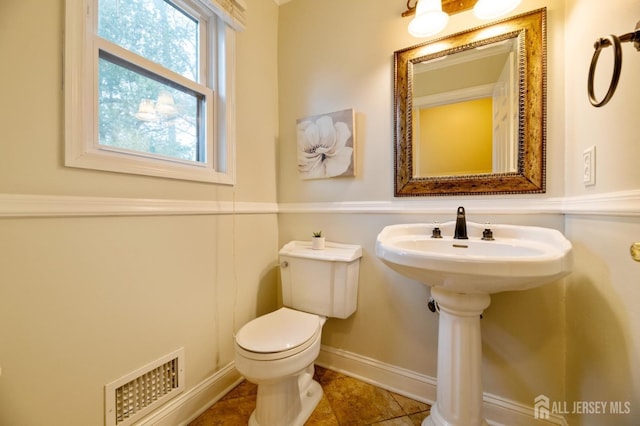 bathroom featuring toilet, tile patterned flooring, visible vents, and baseboards