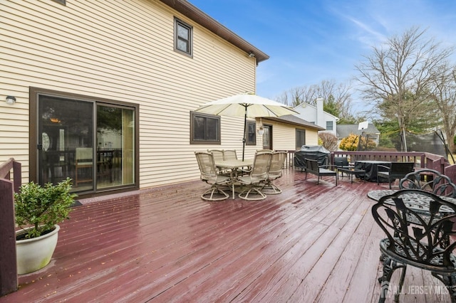 wooden deck featuring outdoor dining space and area for grilling