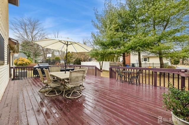 wooden deck featuring a fenced backyard, a grill, and outdoor dining area