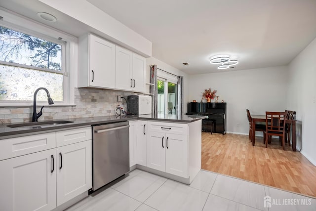 58 La Rue Ln, East Brunswick, NJ 08816 - kitchen with stainless steel dishwasher, a sink, dark countertops, and a peninsula