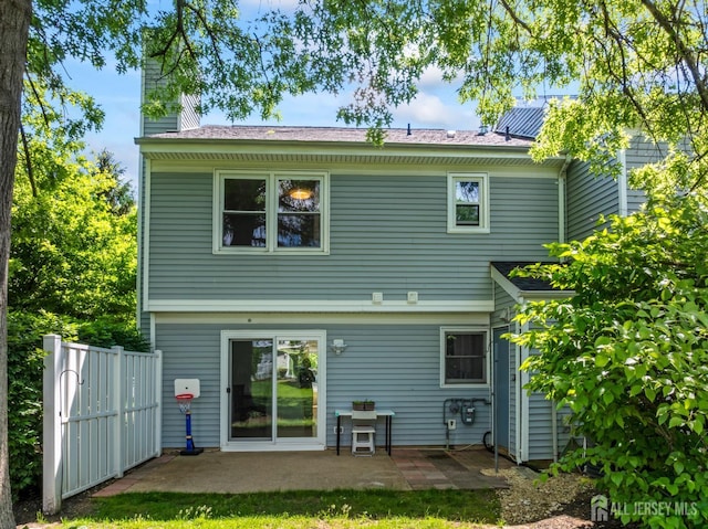 58 La Rue Ln, East Brunswick, NJ 08816 - rear view of house with a chimney and a patio