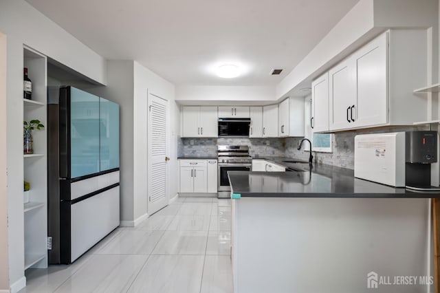 58 La Rue Ln, East Brunswick, NJ 08816 - kitchen with stainless steel range with gas stovetop, freestanding refrigerator, a sink, decorative backsplash, and dark countertops