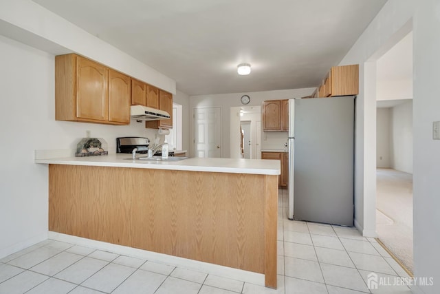 136 Carroll Ave, Woodbridge Proper, NJ 07095 - kitchen featuring freestanding refrigerator, a peninsula, under cabinet range hood, light countertops, and range