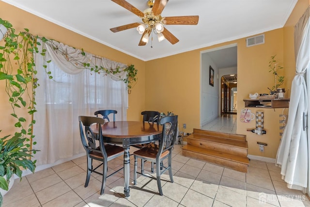 dining room featuring crown molding, light tile patterned floors, a ceiling fan, and visible vents