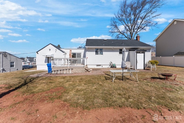 back of property with a deck, fence, a yard, crawl space, and a chimney