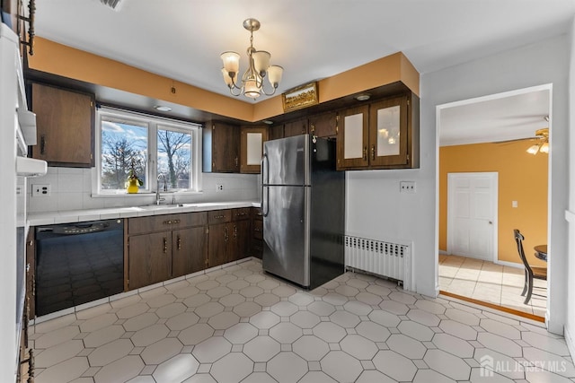 kitchen featuring a sink, radiator heating unit, freestanding refrigerator, dark brown cabinets, and dishwasher