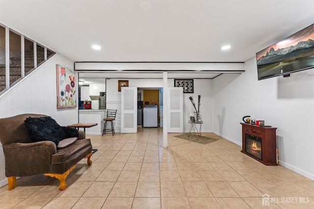 living area featuring stairs, washer / dryer, light tile patterned flooring, and recessed lighting