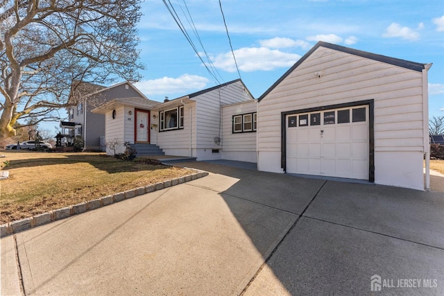 view of front of property featuring concrete driveway, an attached garage, and a front lawn