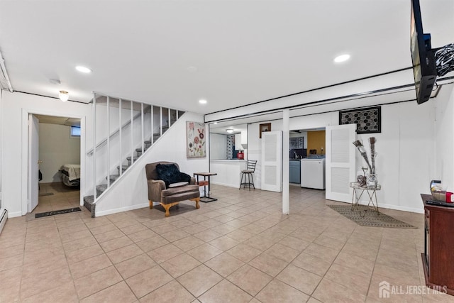 finished basement featuring washer / clothes dryer, recessed lighting, stairway, light tile patterned floors, and baseboards