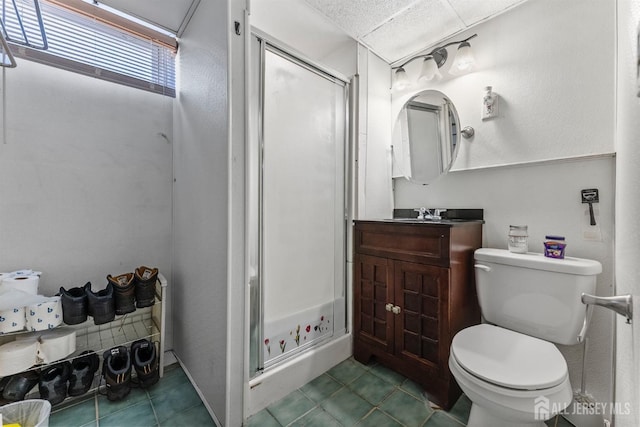 bathroom with vanity, toilet, a shower stall, and tile patterned flooring