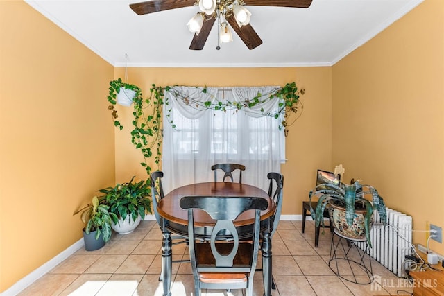 dining space featuring baseboards, light tile patterned flooring, a ceiling fan, and crown molding