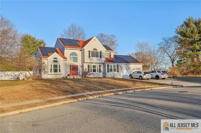 321 Snowgoose Ln, Harrison, NJ 08062 - view of front of home featuring roof mounted solar panels, a front yard, and driveway