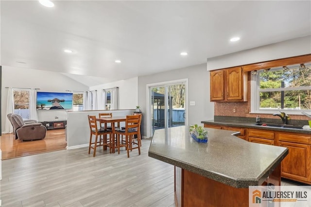 321 Snowgoose Ln, Harrison, NJ 08062 - kitchen with dark countertops, a sink, light wood-style floors, a kitchen island, and recessed lighting