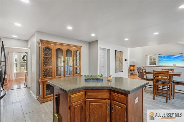 321 Snowgoose Ln, Harrison, NJ 08062 - kitchen with dark countertops, light wood-style flooring, a center island, recessed lighting, and brown cabinets