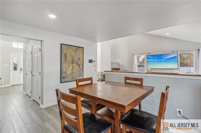 dining space featuring light hardwood / wood-style floors and vaulted ceiling