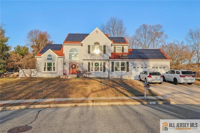 321 Snowgoose Ln, Harrison, NJ 08062 - view of front of property featuring solar panels, a garage, concrete driveway, and a front lawn