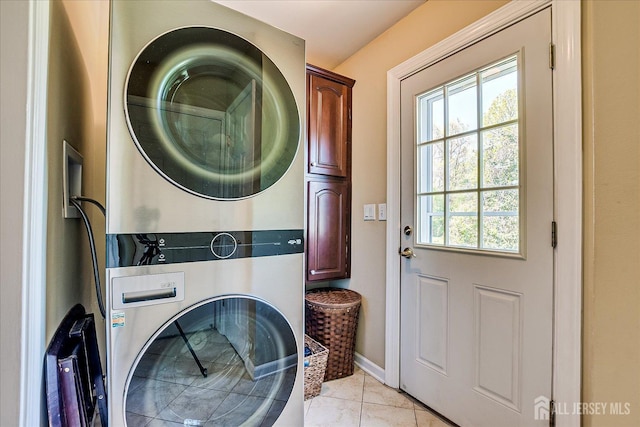 4 Hollis Rd, East Brunswick, NJ 08816 - laundry area featuring stacked washer and clothes dryer, cabinet space, healthy amount of natural light, and light tile patterned flooring