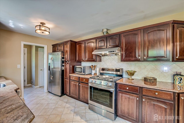 4 Hollis Rd, East Brunswick, NJ 08816 - kitchen with appliances with stainless steel finishes, under cabinet range hood, tasteful backsplash, and light stone countertops