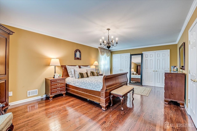 4 Hollis Rd, East Brunswick, NJ 08816 - bedroom featuring a chandelier, multiple closets, wood finished floors, and ornamental molding