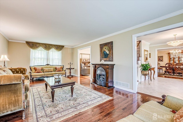 4 Hollis Rd, East Brunswick, NJ 08816 - living room featuring crown molding, a fireplace, a chandelier, and wood finished floors