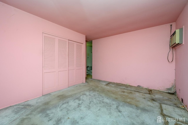 unfurnished bedroom featuring a wall mounted air conditioner, a closet, and carpet