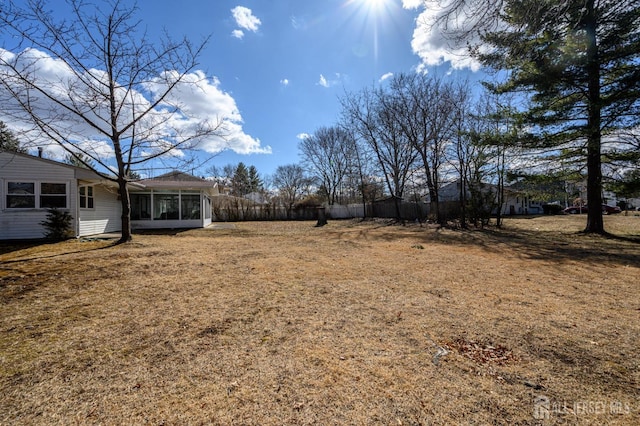 view of yard with fence and a sunroom