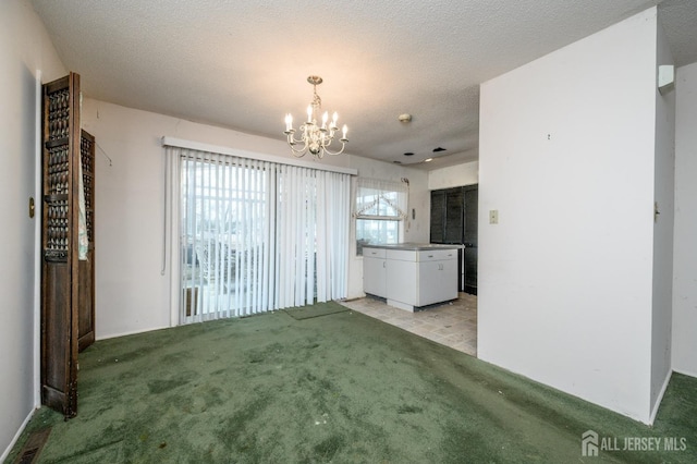 unfurnished living room with a textured ceiling, an inviting chandelier, and light carpet