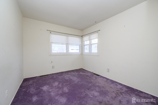 carpeted empty room featuring visible vents