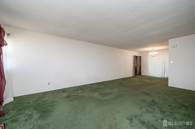 empty room featuring a notable chandelier, carpet flooring, and a textured ceiling