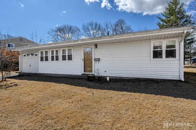 single story home with an attached garage and a front yard