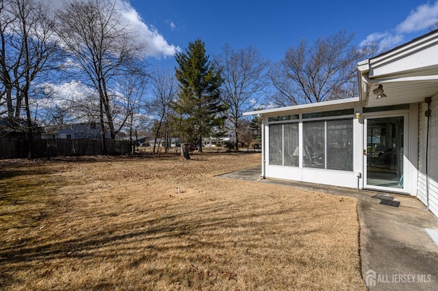 view of yard with fence and a sunroom