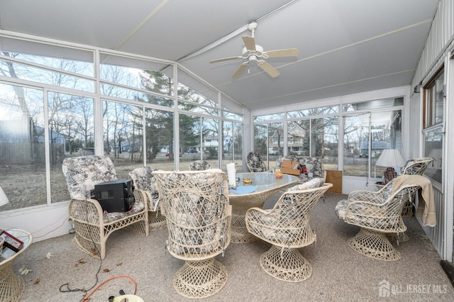 sunroom featuring a healthy amount of sunlight, ceiling fan, and vaulted ceiling