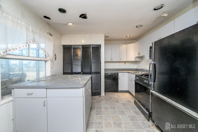 kitchen with recessed lighting, a sink, black appliances, white cabinets, and a textured ceiling