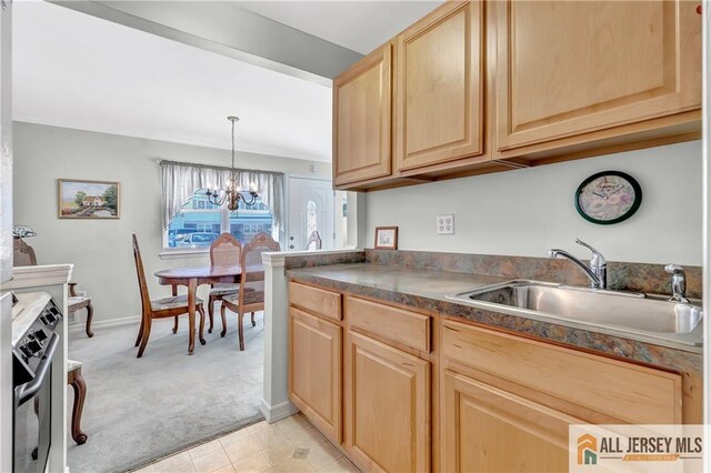 kitchen with light brown cabinets, light colored carpet, a sink, hanging light fixtures, and dark countertops