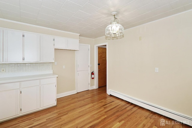 1270 S 9th St S, South Plainfield, NJ 07080 - kitchen with a baseboard radiator, a chandelier, white cabinetry, light wood finished floors, and crown molding