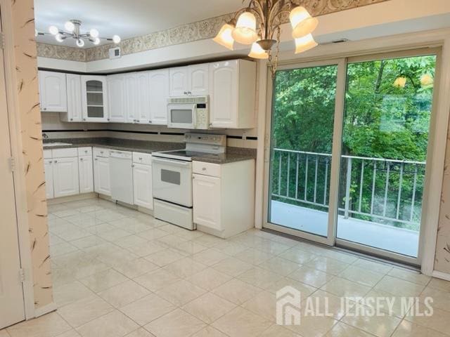 8 Indiana Ct Unit D, Old Bridge, NJ 07747 - kitchen featuring white appliances, a chandelier, dark countertops, and white cabinetry