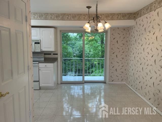 8 Indiana Ct Unit D, Old Bridge, NJ 07747 - unfurnished dining area with light tile patterned flooring, a chandelier, baseboards, and wallpapered walls
