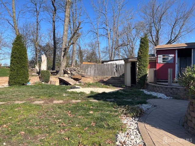 view of yard with fence and an outbuilding