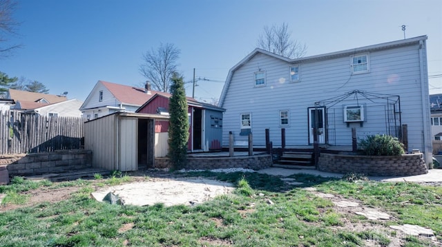 view of front of property featuring a storage unit, an outbuilding, and fence