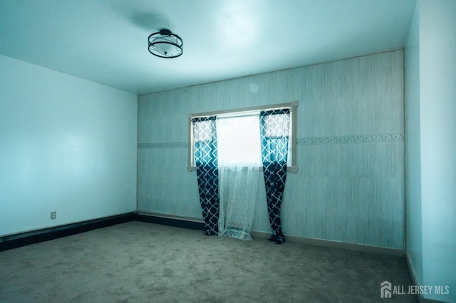 carpeted spare room featuring baseboards
