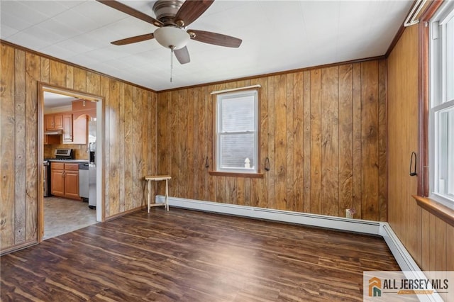 spare room featuring ceiling fan, a baseboard heating unit, wood finished floors, and crown molding