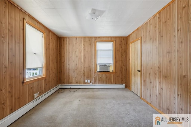 spare room with cooling unit, carpet, a baseboard heating unit, and wood walls