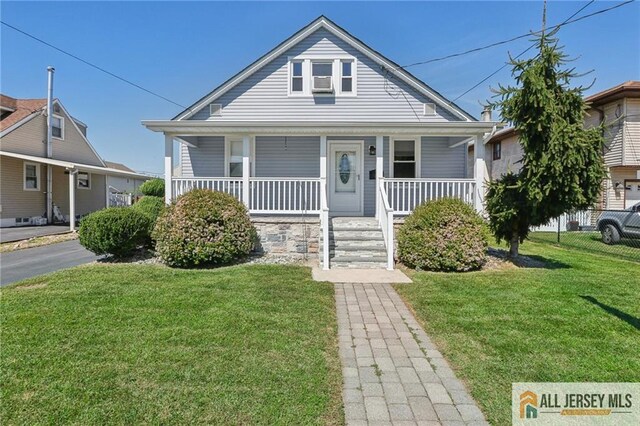 bungalow featuring covered porch and a front lawn