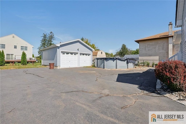 detached garage featuring a fenced in pool